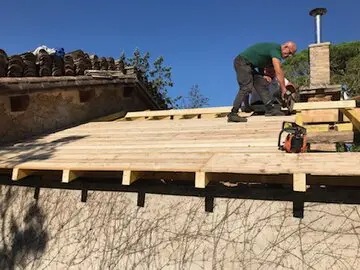 Couvreur saluant des clients devant leur maison après travaux